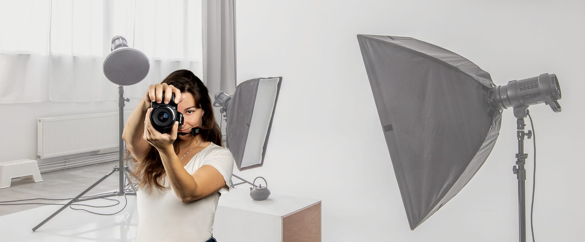 Fotógrafa en acción en un estudio con softbox y equipo de iluminación, portada de la web de Objetivo Clientes