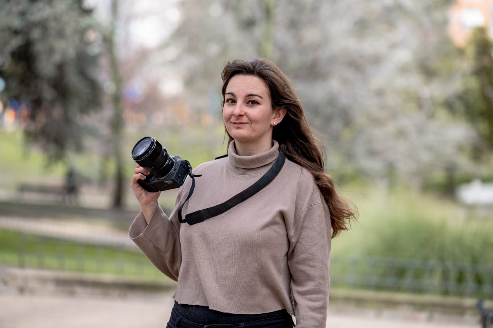 Sandra Roch sonríe con cámara en mano en exterior